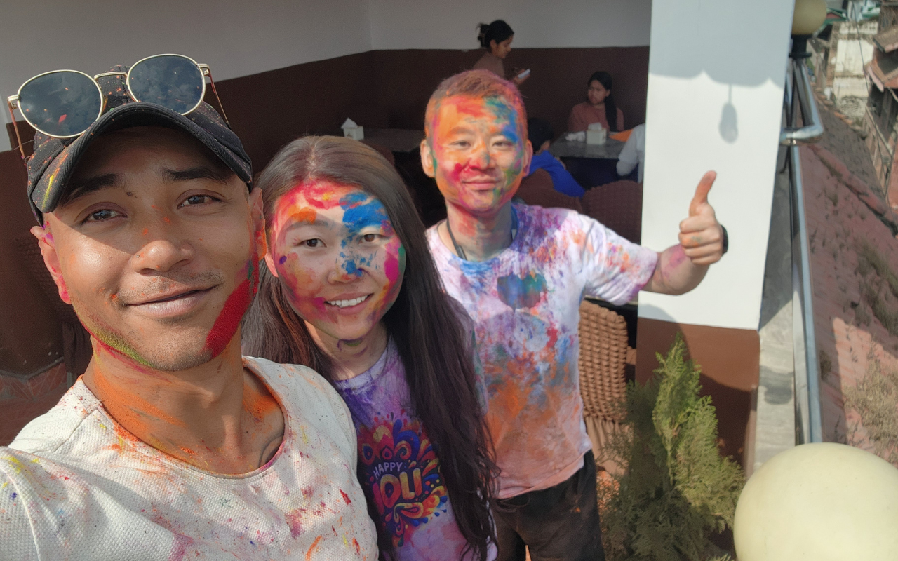 Suraj C.K. celebrating Holi with international travelers during a Nepal travel experience